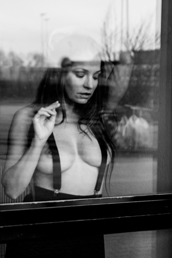 nackte Frau hinter der Glastür Portrait in S/W
