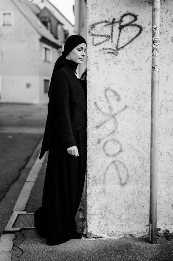 Frau mit Kopftuch stehend in schwarz weiss