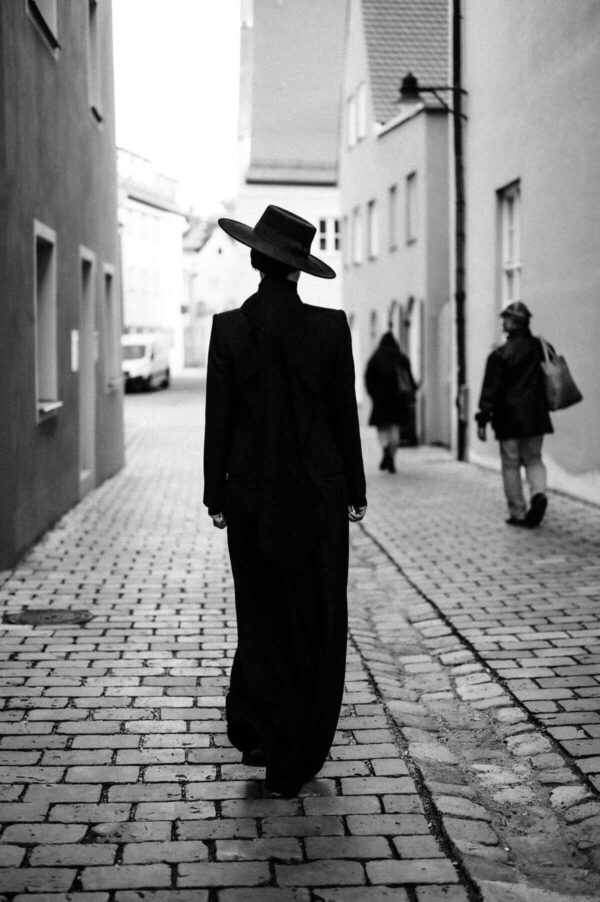 Frau mit Hut in schwarz weiss von hinten