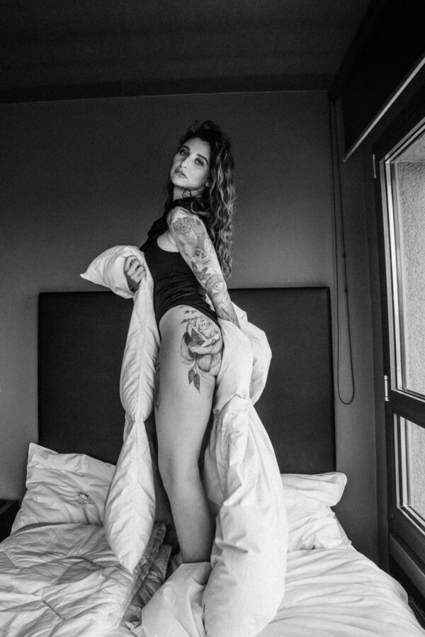 Frau mit Tattoo im Bett schwarz weiss